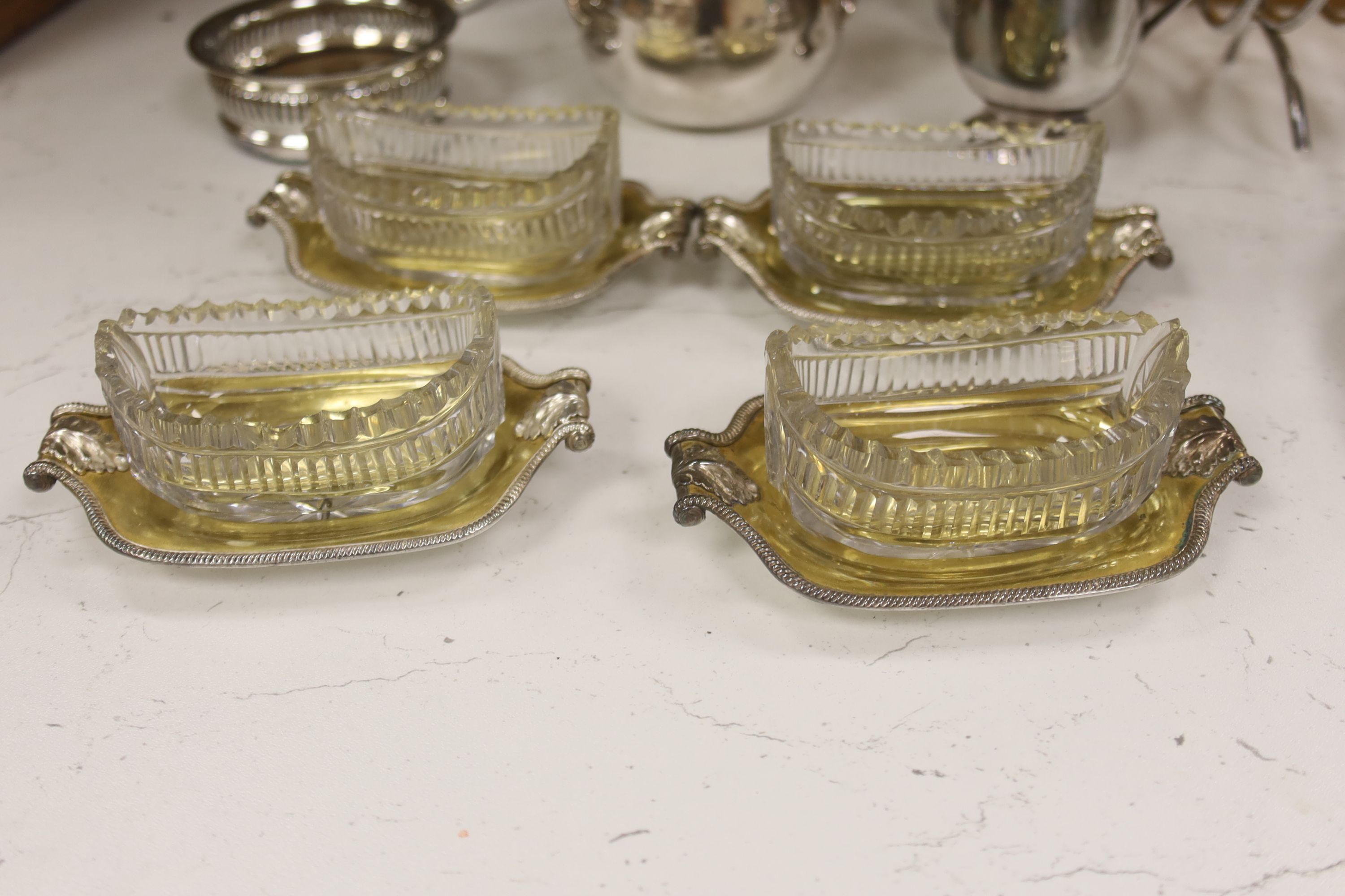 A group of assorted plated wares including a set of four gilt salts and a butter dish